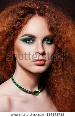 beautiful model with red curly lush hair and bright green eyes makeup