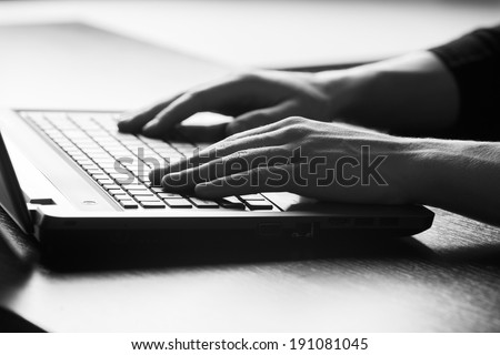 Close-up of typing male hands on keyboard. black and white photo