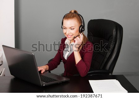 Portrait of smiling young support phone operator in headset, at office