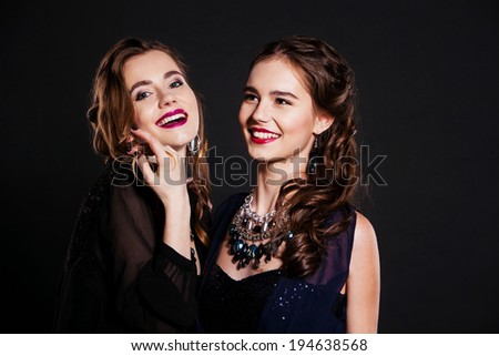 Two happy women in  black cocktail dresses
