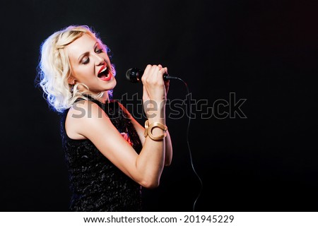 Beautiful singing woman with microphone. Singer. Karaoke song. on black background