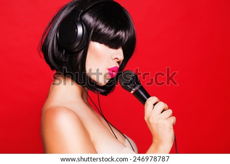 Woman listening to music on headphones enjoying a dance. Closeup portrait of beautiful girl with pink lips