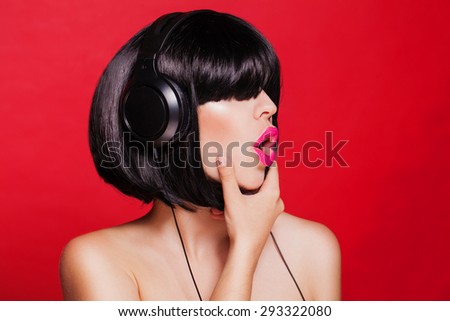 Woman listening to music on headphones and singing. Closeup portrait of beautiful girl with pink lips. Karaoke