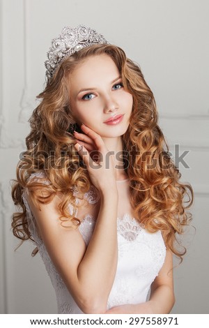 Portrait of young beautiful bride with stylish make-up and hairdo, over white background