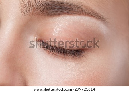Close up of closed eye of young beautiful woman with perfect day makeup eye shadows