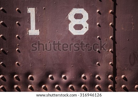 Metal background with number eighteen. Grunge background metal plate with screws