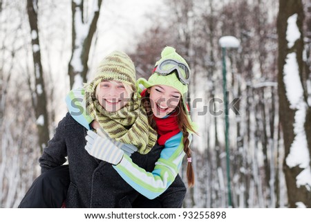 Winter couple  in snow smiling happy. Beautiful young couple