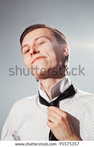 Portrait of a handsome stylish young man tie a tie
