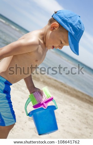 boy toddler is playing with sand on the beach