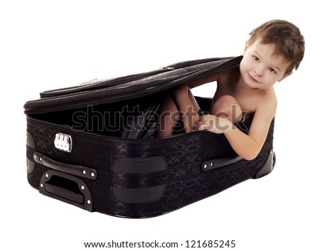 little boy sitting in the luggage on white background