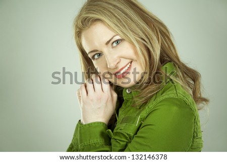pretty brunette wearing green dress on light background