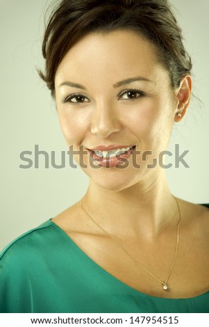 pretty brunette is wearing green fashion outfit on light background