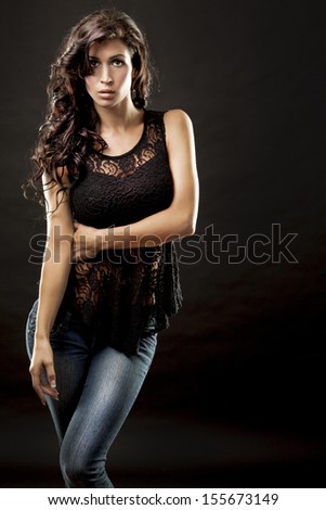 fashion model brunette wearing black outfit on black background