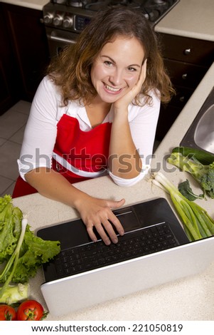 woman searching recipes online while cooking raw vegetables