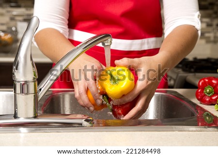 woman washing vegetables in the sink home kitchen