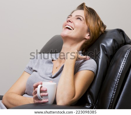 caucasian woman sitting in the living room drinking coffee