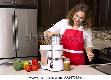 woman making juice from raw vegetables in the kitchen