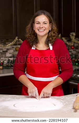woman drawing into flour in the kitchen with Christmas ornaments