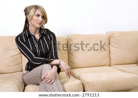 beautiful woman sitting on the sofa in living room wearing businesss wear