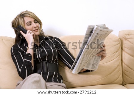 beautiful woman sitting on the sofa in living room wearing businesss wear and reading newspaper