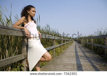 brunette posing wearing her white outfit in the fall days