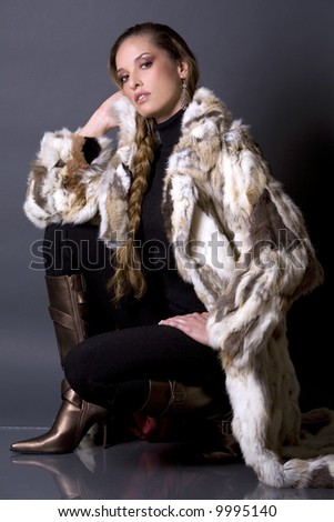 pretty model wearing fur coat and black pants indoors