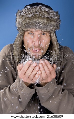 russian man blowing the snow on blue background