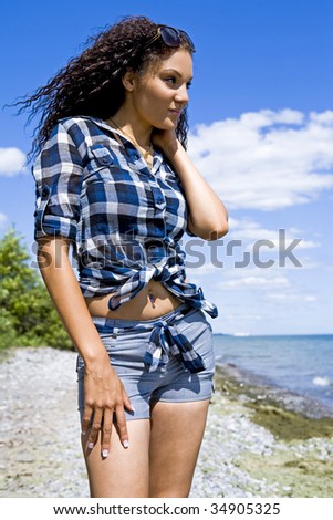pretty brunette wearing summer outfit on the beach