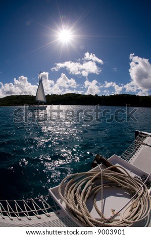 Fisheye view of a small sailboat in the Caribbean water taken from another boat