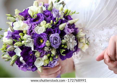 Bride with violet bouquet before wedding ceremony