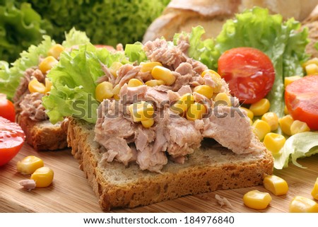 Sandwich with tuna corn and tomato on wood Sandwich with tuna corn and tomato on wood
