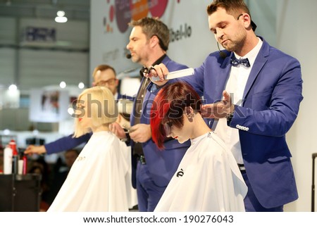 POZNAN - APRIL 27: Look Beauty Fashion Forum Poznan 2014. Hairdresser styling red hair with white comb - shows on Look Beauty Fashion Forum, April 27, 2014 in Poznan, Poland.