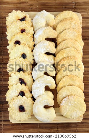 Sweet shortbread biscuits with sugar and jam on a wooden board