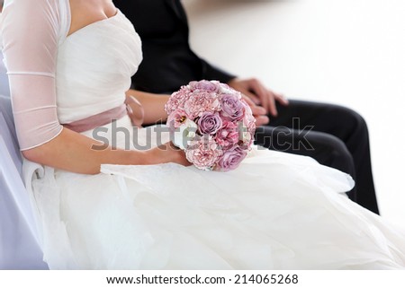 Bride with rose bouquet at the wedding ceremony in church