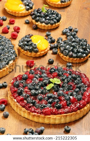 Fruit tart dessert with raspberries blackberries and cranberries on a wooden table