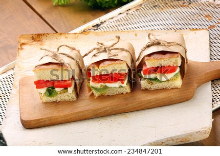 Focaccia sandwich with mozzarella basil and tomato on a chopping board