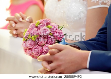 Newlyweds with wedding rose bouquet at the church