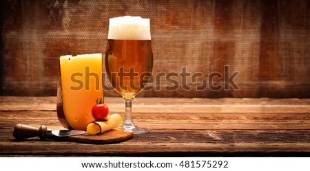 Yellow cheese appetizer and beer on brown vintage background