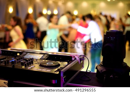 Dancing couples during party or wedding celebration by dj mixer