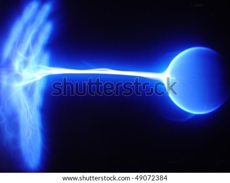 Blue static electricity arc traveling from a plasma ball to an open hand.  Horizontal shot.