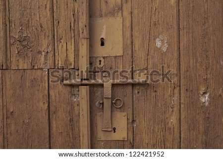 Old Wooden door locked with rusty padlock background.