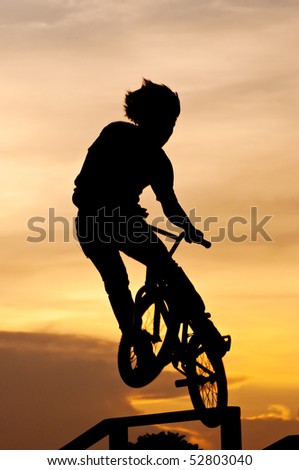 Silhouette of the boy playing Bicycle Stunts