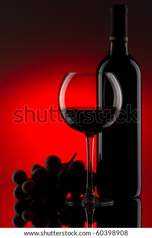 Still-life with the red wine bottle, glass and grapes