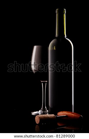 white bottle with red wine and glass and cork with a corkscrew on a black