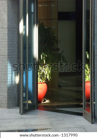 A part of interior of hotel hall, entrance with glass doors.