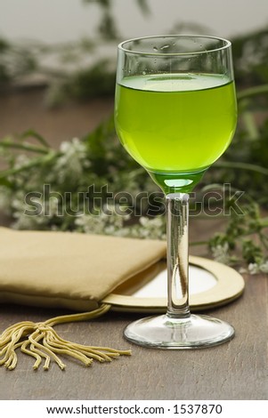 A glass with some mint liquor and mirror.