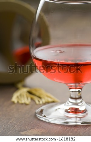 A glass with some red liqueur and mirror.