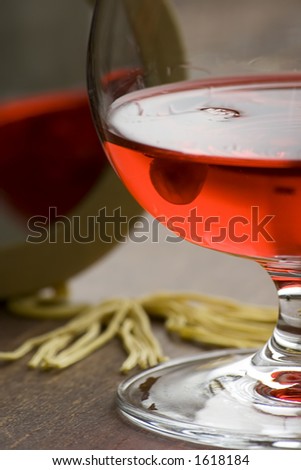A glass with some red liqueur and mirror.