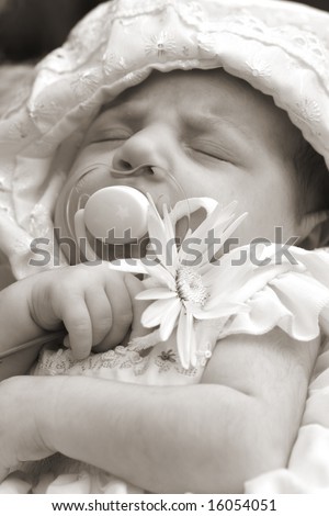 Little baby sleeping in bed with a soother in mouth