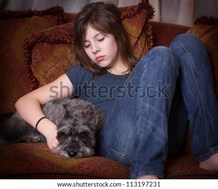 Emotional portrait of looking alone and sad with her dog on couch
